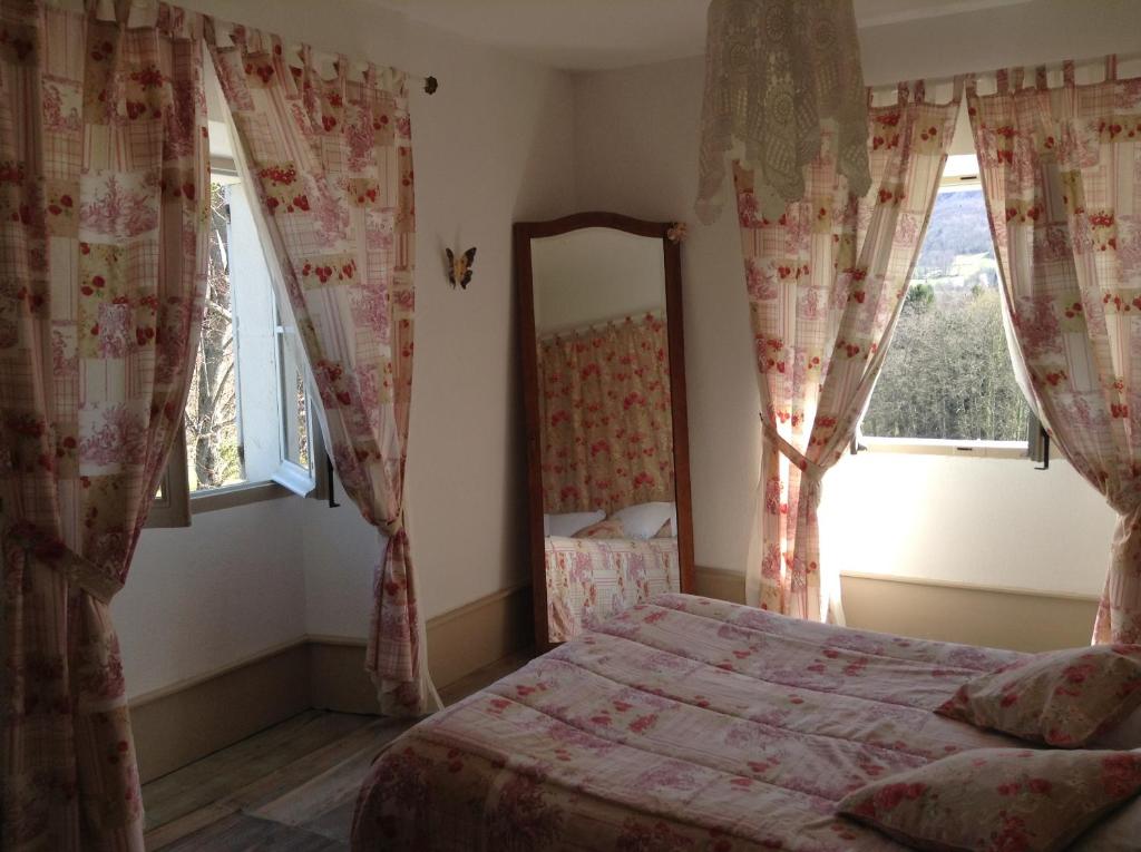 BénacChateau De Benac的卧室配有床、镜子和窗户。