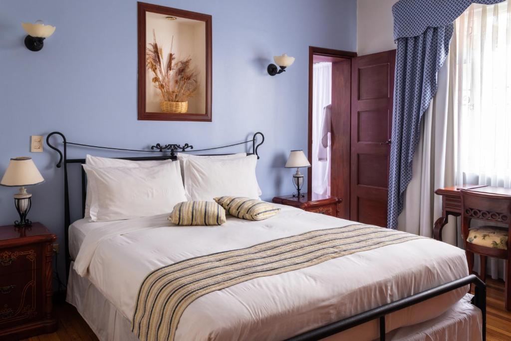 基多卡萨阿利索精品酒店的一间卧室配有一张带白色床单的大床