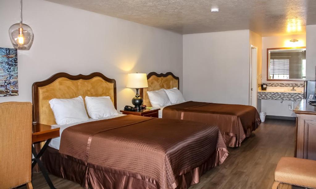 BrookelandRayburn Inn的酒店客房设有两张床和电视。