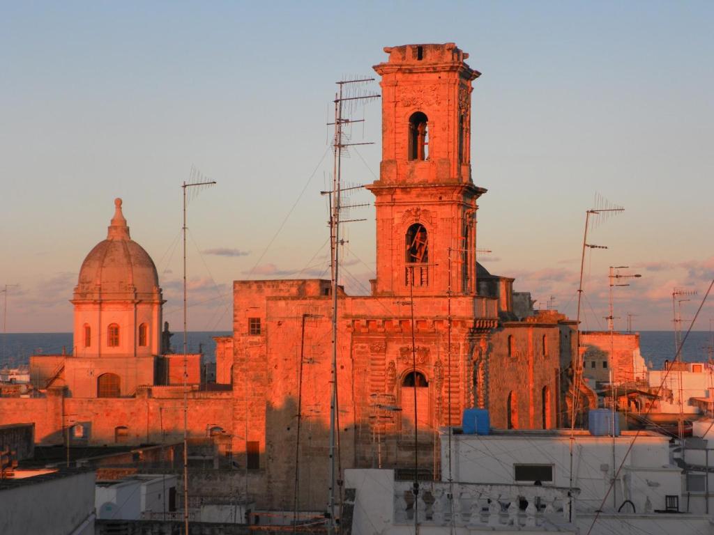 莫诺波利La Torre e il Mare Rooms的一座古老的砖砌建筑,设有钟楼