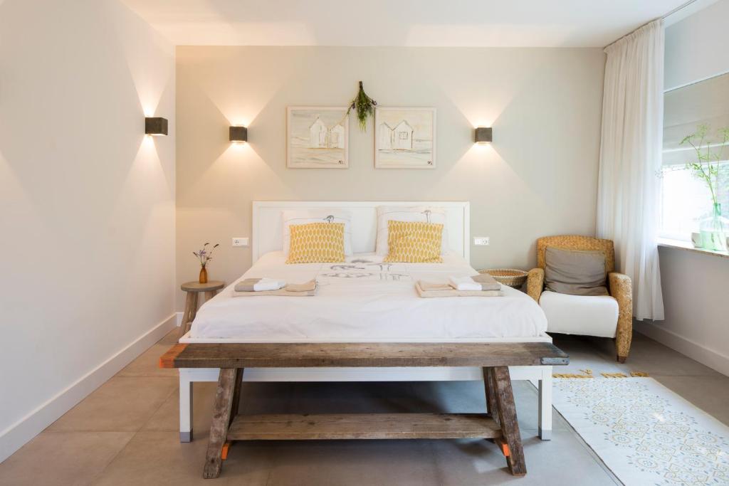 MoergestelHet Ockhuis的卧室配有白色的床和桌子