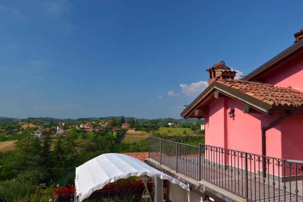 LermaB&B Il Borgo Fiorito的一个带白色遮阳篷的粉红色房子的阳台