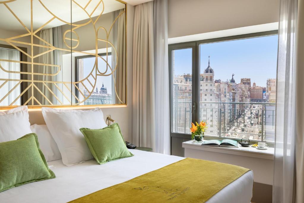 马德里马德里巴塞罗塔酒店的一间带一张床的卧室,享有城市美景