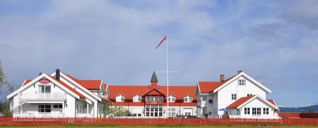 加勒穆恩Garder Hotell og Konferansesenter的一座大型白色房屋,设有红色屋顶