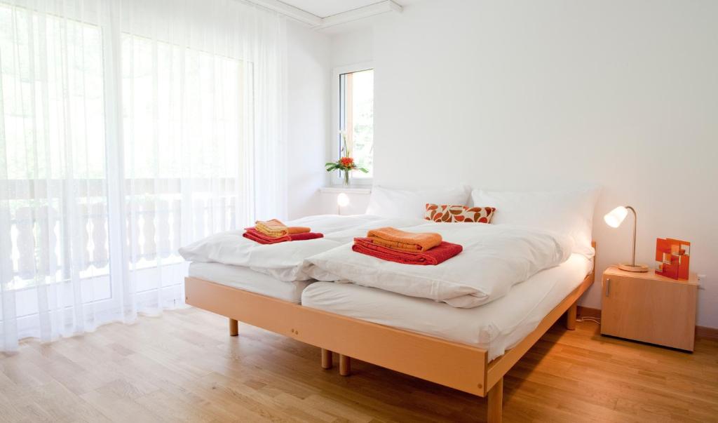 洛伊克巴德C21高尔夫公寓的白色卧室配有一张带白色床单的大床
