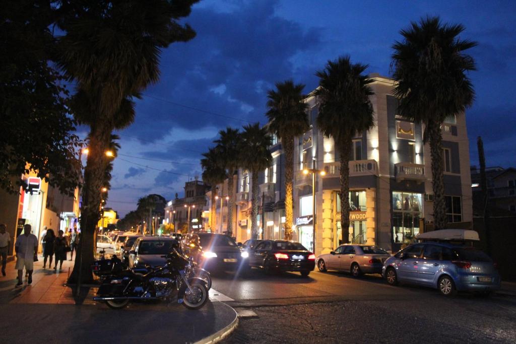都拉斯Hotel Veliera的繁忙的城市街道,晚上有汽车和棕榈树