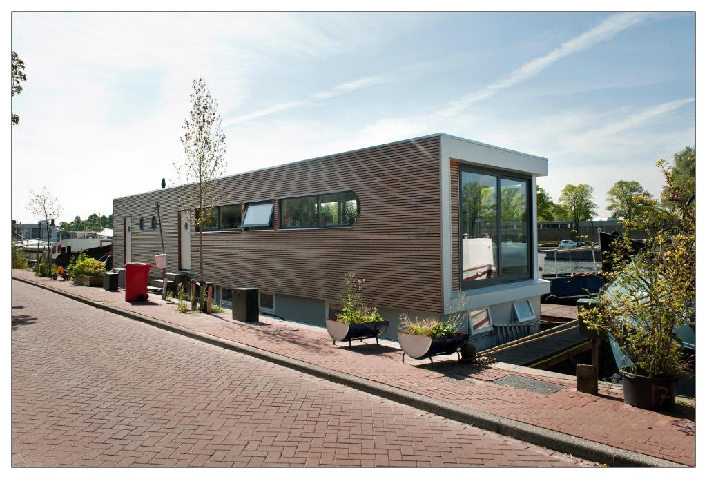 阿姆斯特丹Private guesthouse BnB The Waterhouse houseboat的一条砖街上的小房子,有植物