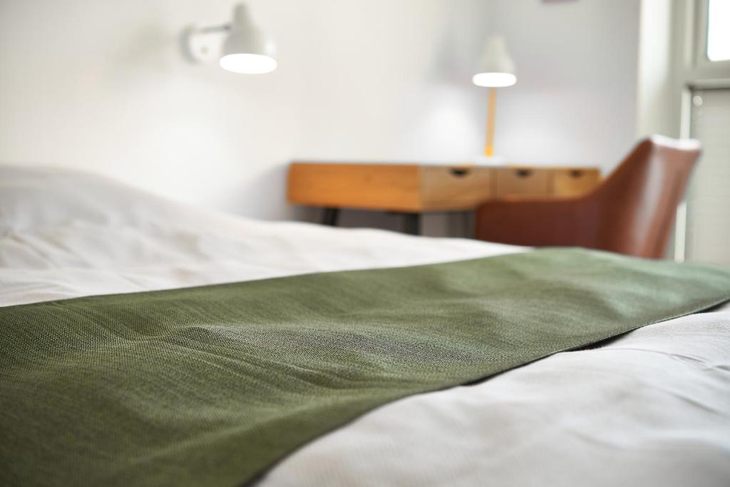 霍尔斯特布罗Hotel Phønix的一张床上有绿毯的床
