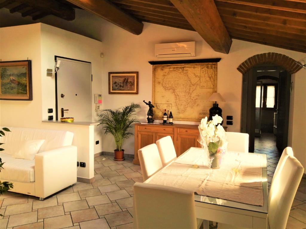 普拉托Casa Giulia的一间带桌子和白色椅子的用餐室