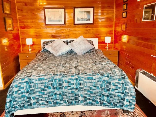 基督城Cosy studio apartment的一间卧室配有一张带2个床头柜的大床