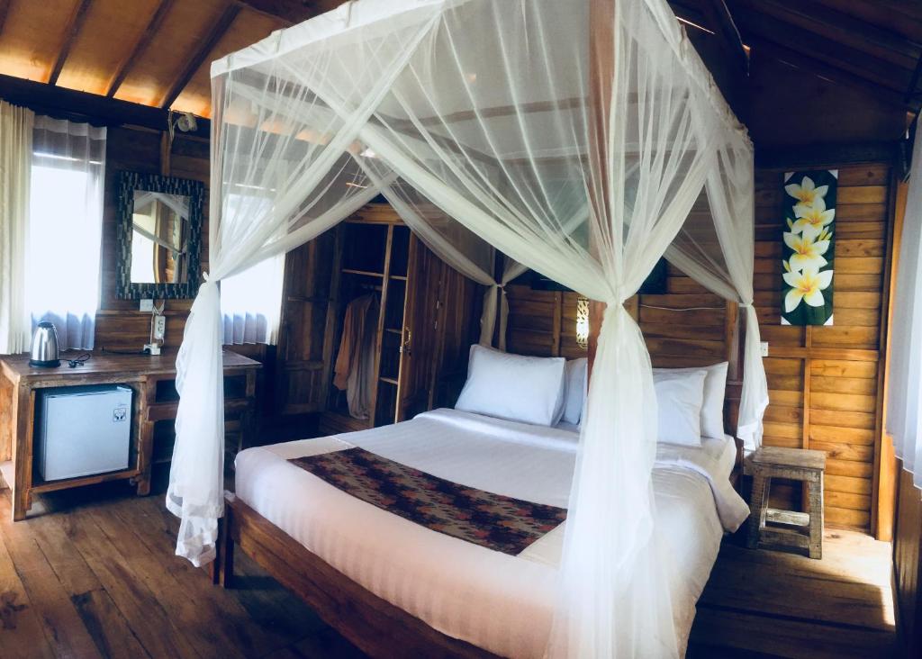 乌布Doni House & Villas的一间卧室配有一张带天蓬的床