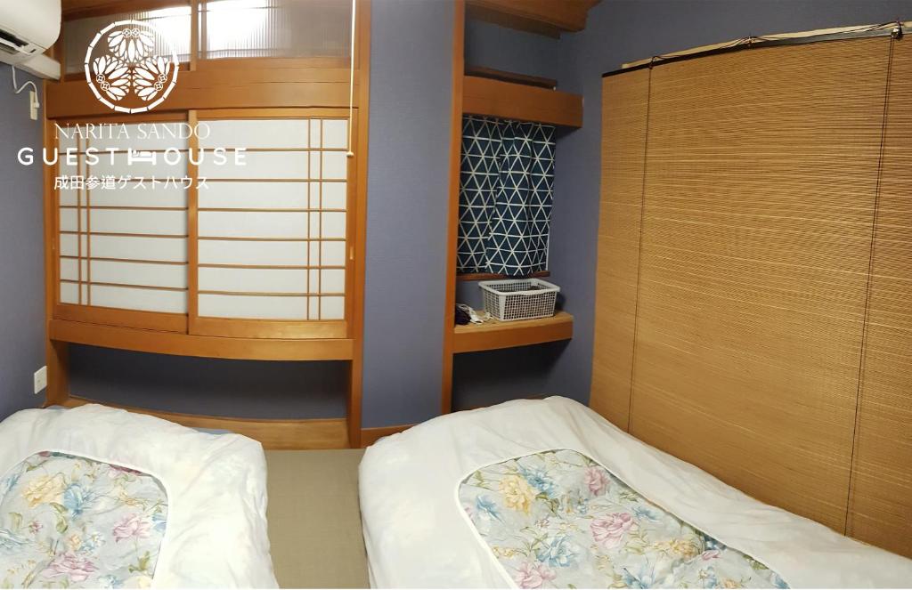 成田成田机场桑多旅馆的一间卧室配有一张床和一个木制橱柜