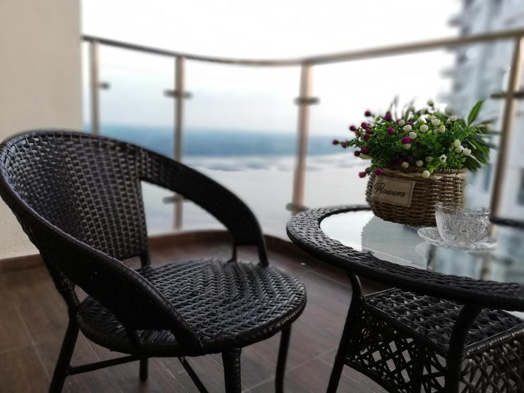 新山Country Garden Danga Bay , Royal Strand的一张桌子、两把椅子和一张桌子,上面有鲜花