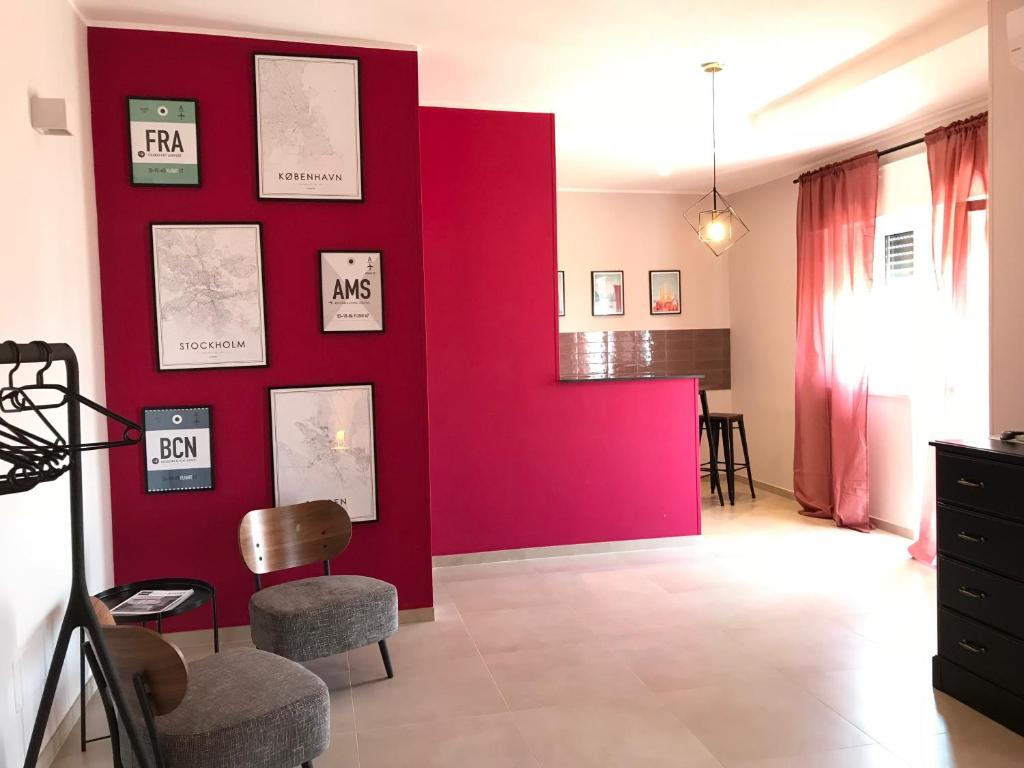 奥斯图尼Apartment Antonella的客厅里红色的墙壁,配有椅子