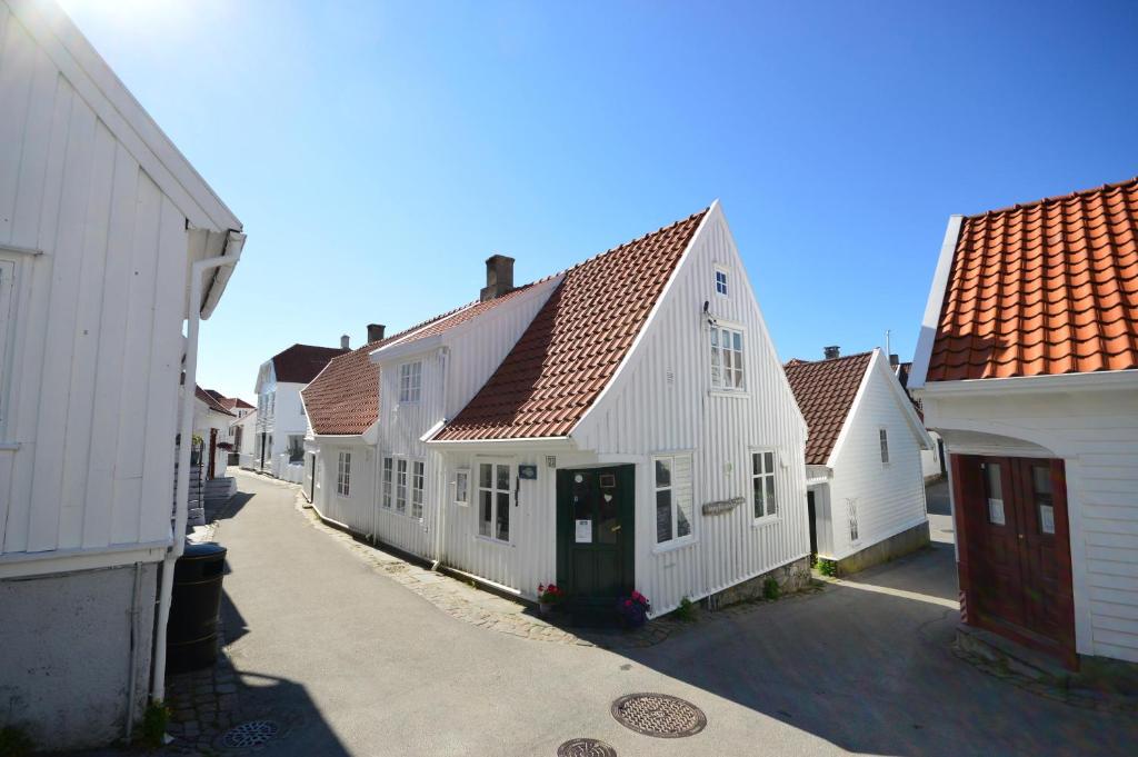 SkudeneshavnReinertsenhuset的街上一排有红色屋顶的白色房屋