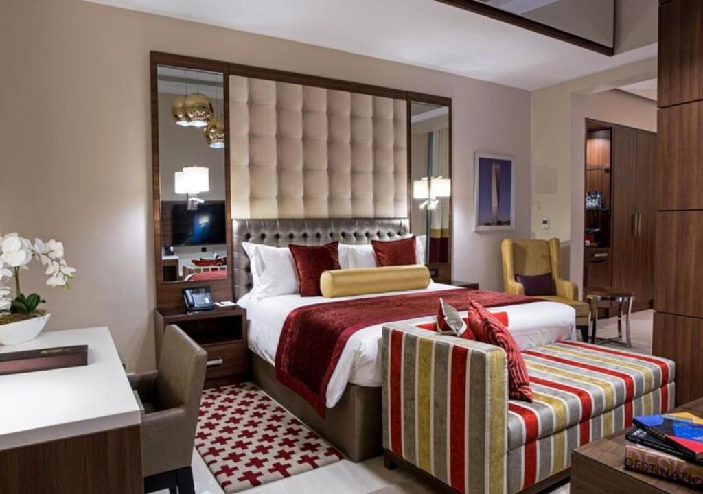 阿布贾The Envoy Hotel Abuja的酒店客房设有一张大床和一张书桌。