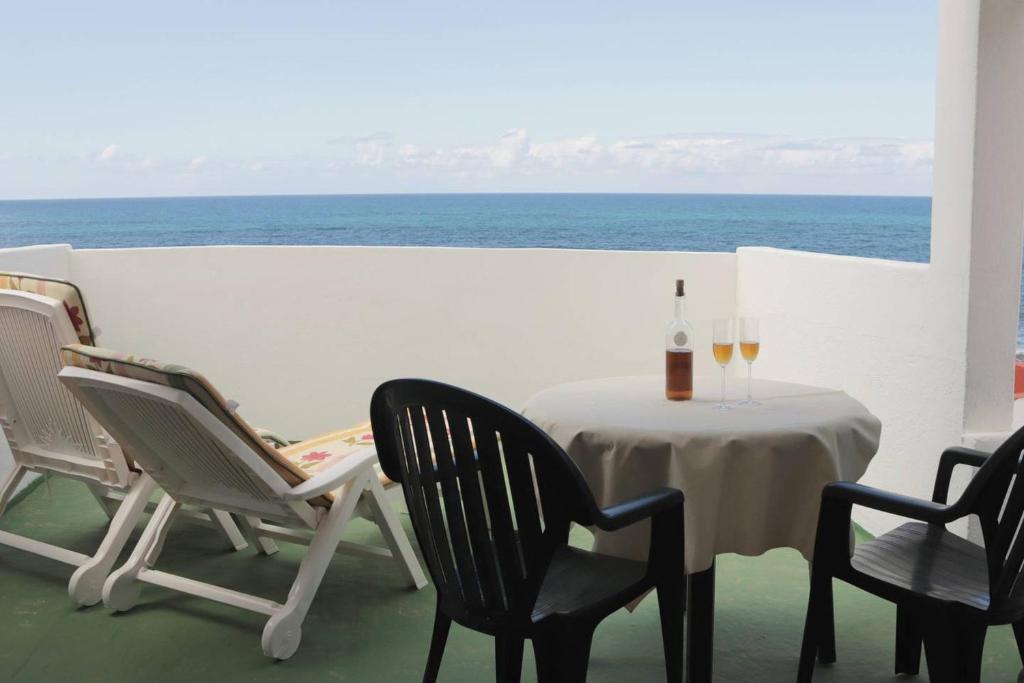 AzanoOasis Atlántico: rincón secreto al pie de los senderos的一张桌子、两把椅子和一瓶葡萄酒