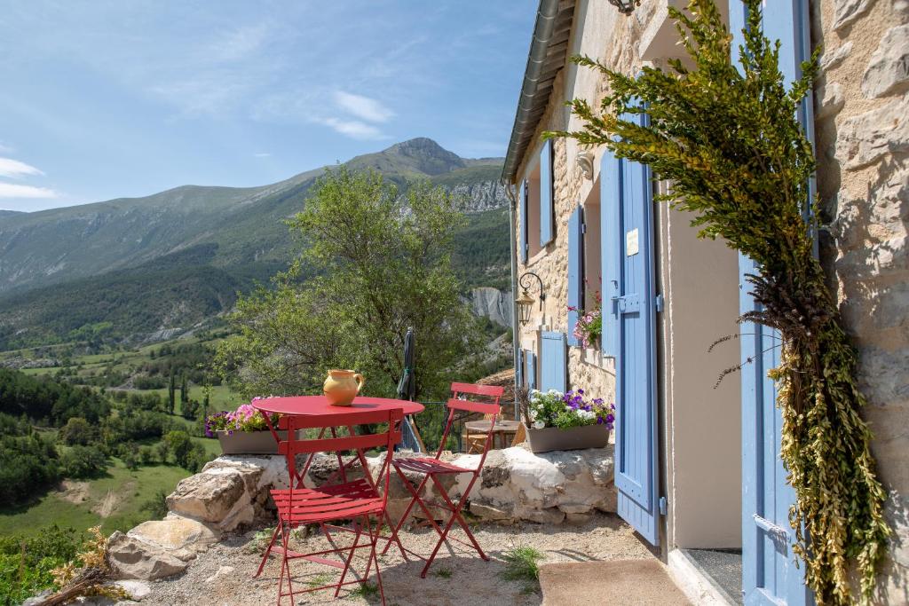 BlieuxGaïa, maison d'hôtes Verdon, vue féerique的山景阳台上摆放着红色的桌椅