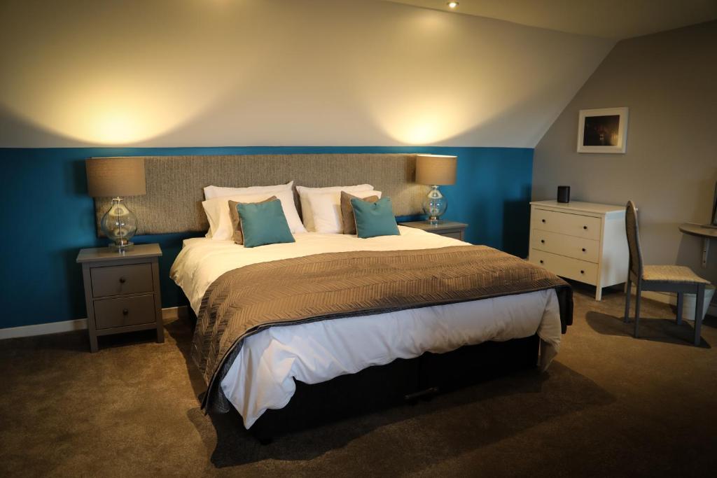 邓弗姆林Bay and Bridge的一间卧室配有一张带蓝色墙壁的大床