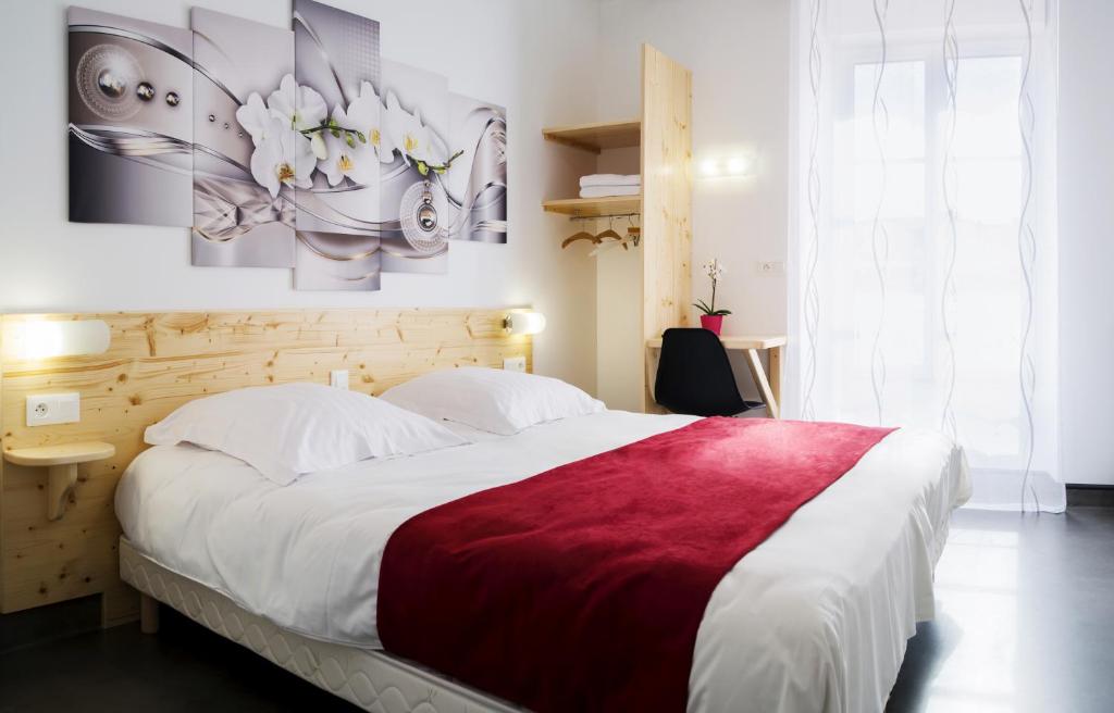 朗戈涅hotel le beauséjour的一间卧室配有一张带红色毯子的大床
