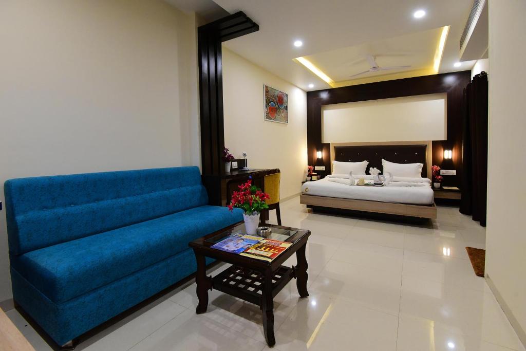 博帕尔Hotel Dayal Shree Paradise的客厅配有蓝色的沙发和床。