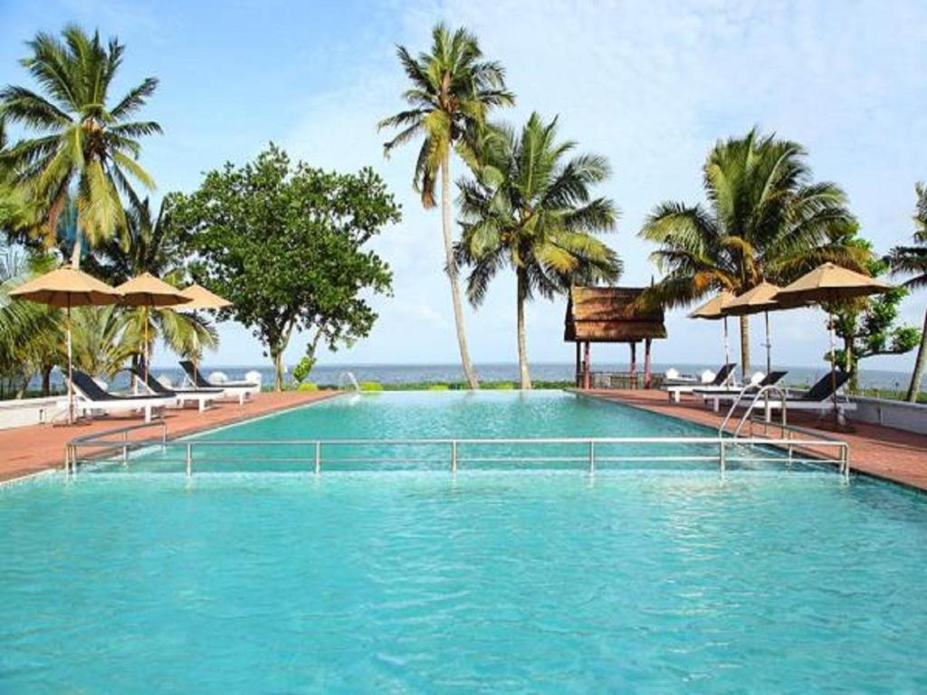 库玛拉孔阿巴德维斯普林棕榈酒店的一个带椅子和遮阳伞的大型游泳池