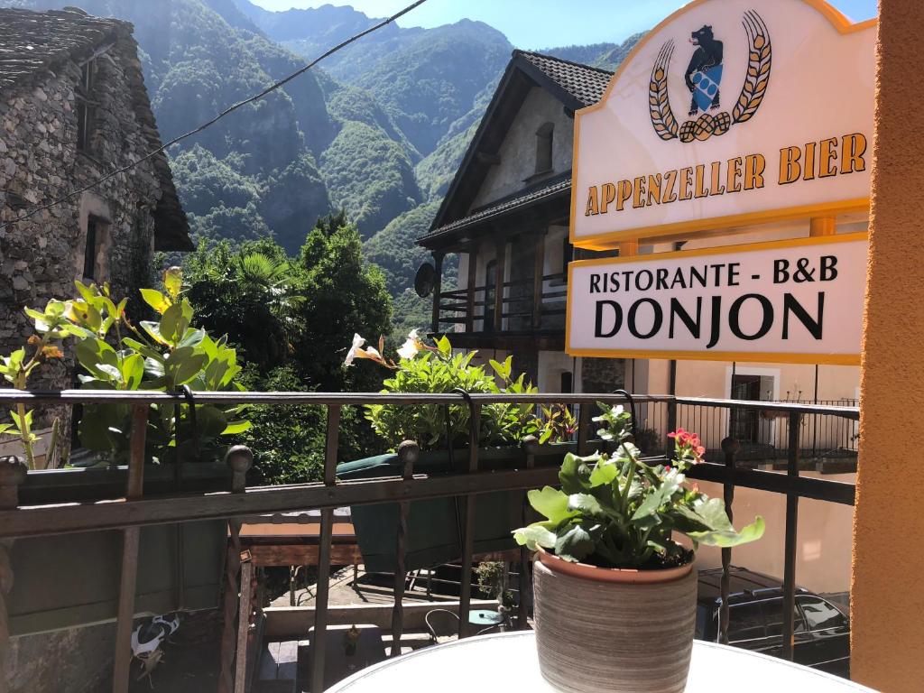 SomeoDonjon B&B e Ristorante的阳台上种有植物的餐厅的标志