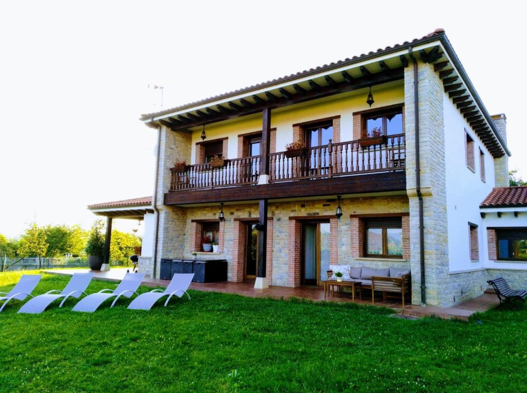 奥维多Villa Tiviti的前面有草坪和椅子的房子