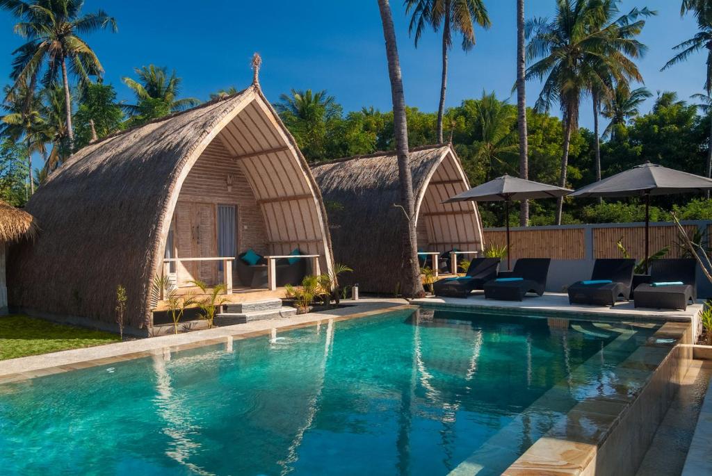 吉利美诺Gili Meno Escape - Adults Only的一座带游泳池和茅草建筑的度假村