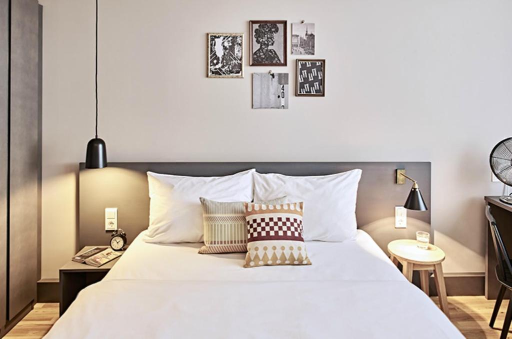 慕尼黑Bold Hotel München Zentrum的卧室配有带枕头的大型白色床