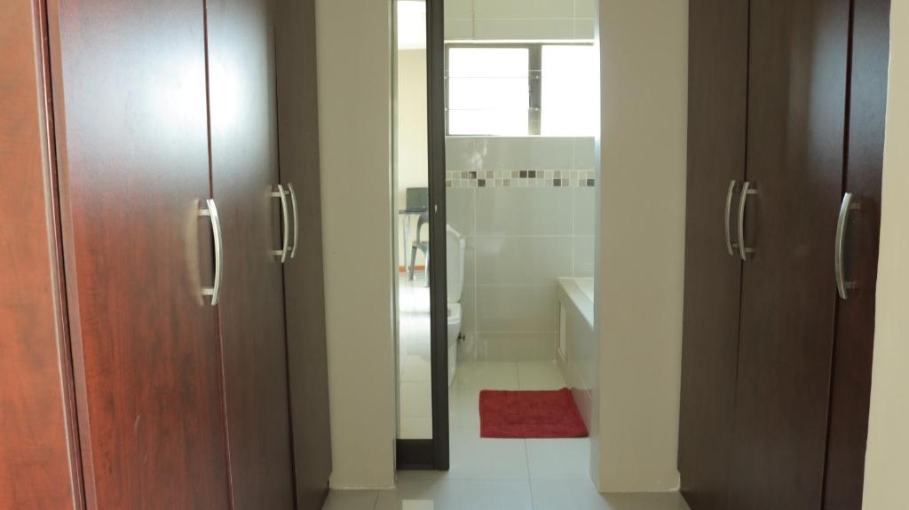 哈博罗内Tap's Home Away from Home的一间带两个木门和淋浴的浴室