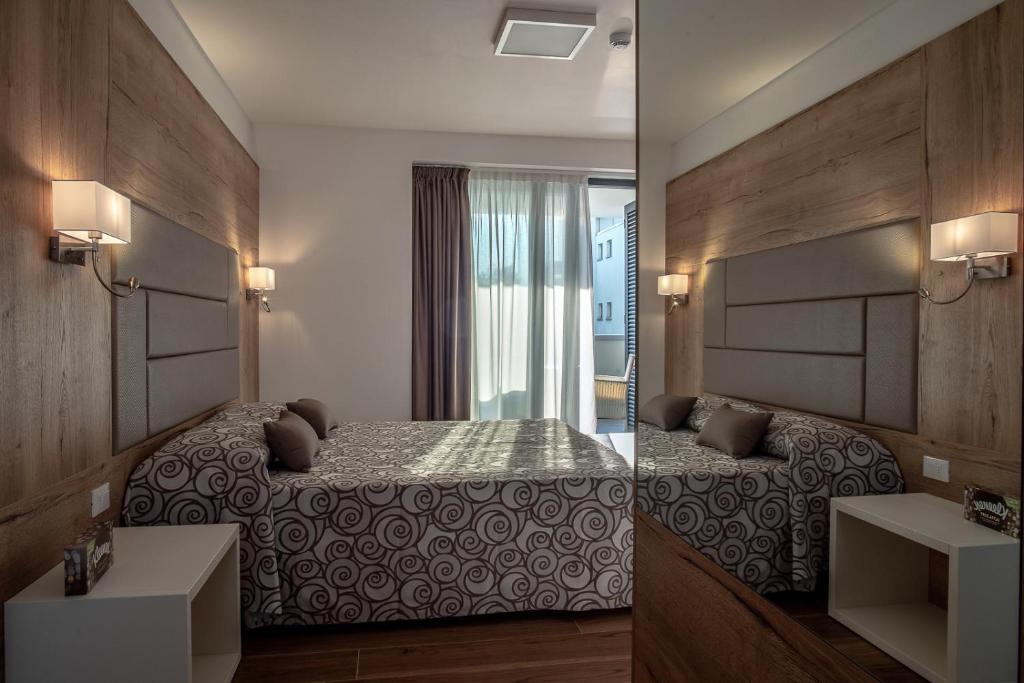 格拉多Aparthotel Miramare的卧室两张照片,配有一张床和一个水槽