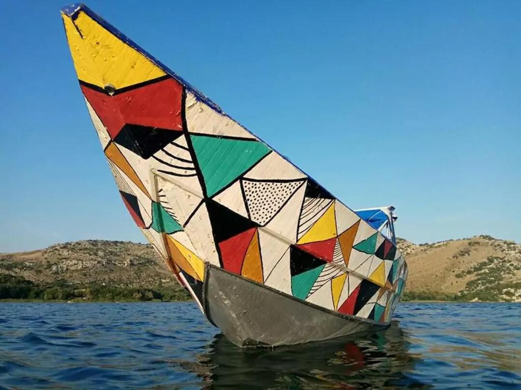 波德戈里察Holiday home Haustor with Skadar lake view的浮在水中的多彩帆船