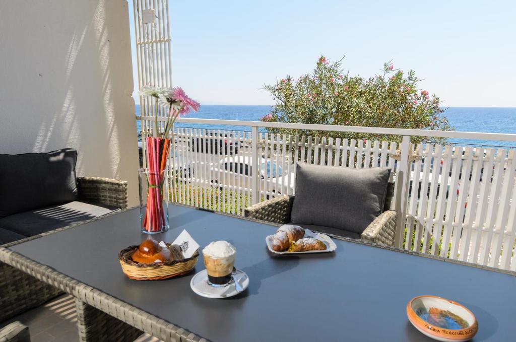 圣泰雷萨迪里瓦Marina D'Agrò Residence的阳台上的蓝色桌子和一碗食物