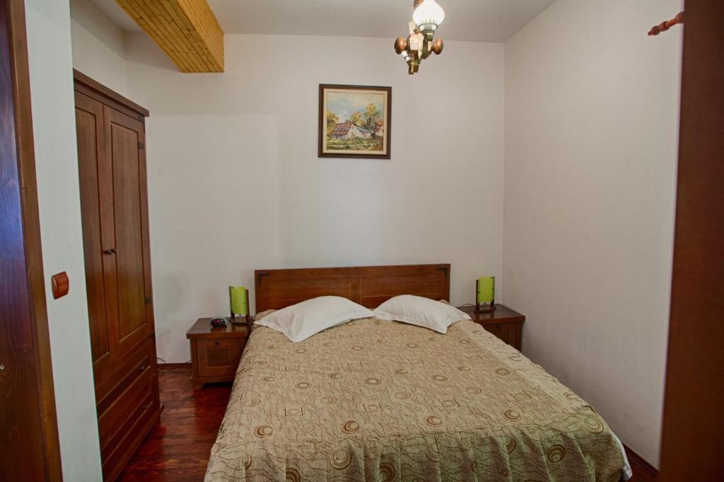 CiungetuVila Ursul的卧室配有一张带两张桌子的床,墙上挂着一张照片