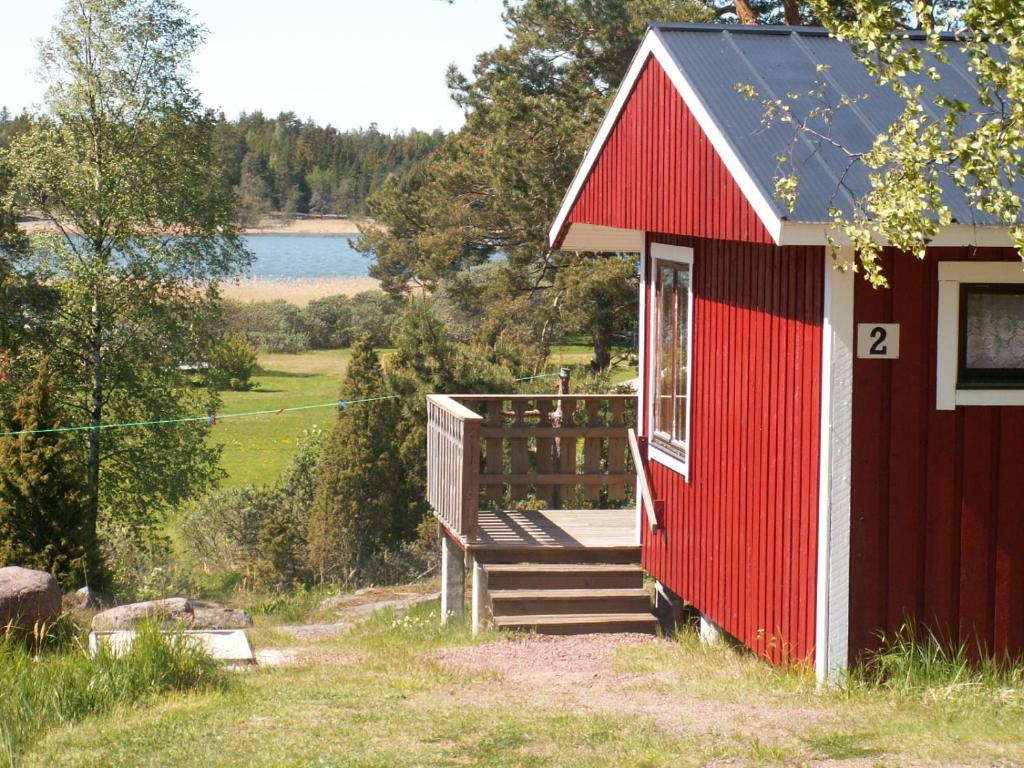 FinströmSöderö Stugby的一座红色的建筑,有通往甲板的斜坡