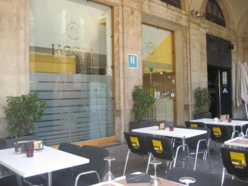 巴塞罗那罗马雷阿尔酒店的一组桌子和椅子,位于大楼前