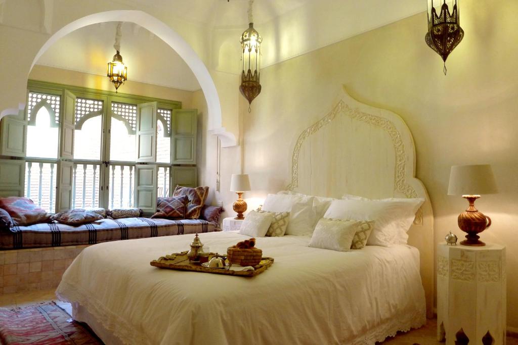 马拉喀什里亚德帕拉西奥代拉斯爱斯匹西亚斯庭院旅馆的卧室配有一张白色的大床和一张沙发。