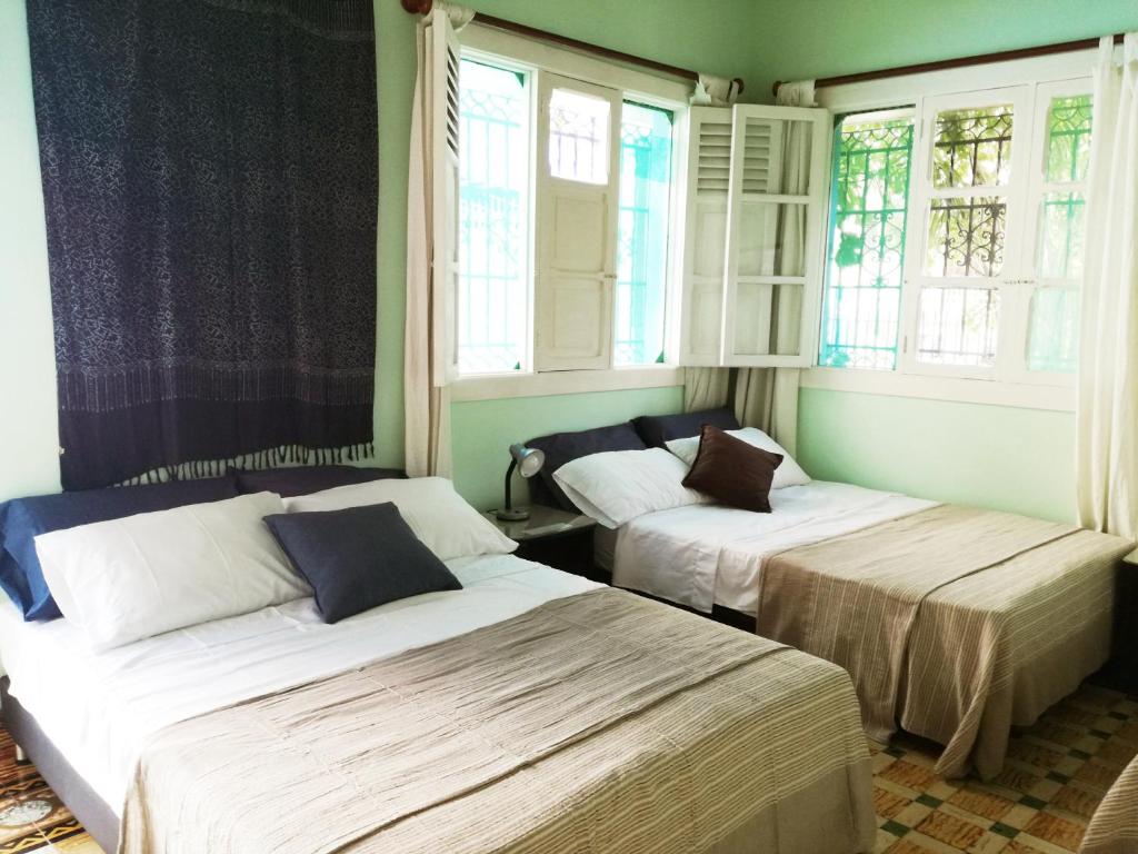 卡塔赫纳La casa azul的配有窗户的客房内的两张床
