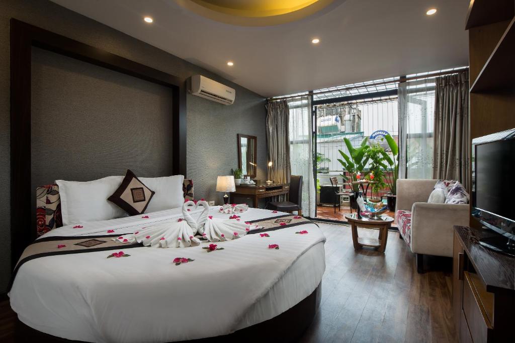 河内Splendid Star Grand Hotel and Spa的一间卧室配有一张白色大床,床上有鲜花