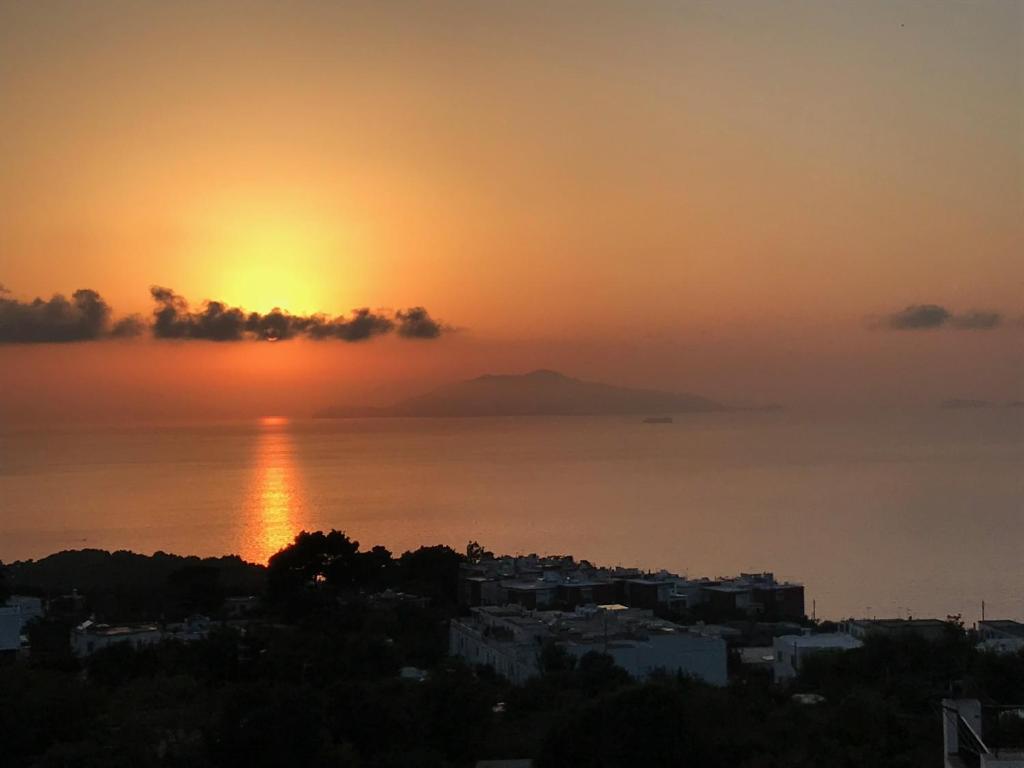 阿纳卡普里R&D Rest and Dream Capri的海上日落,前方有一个城市