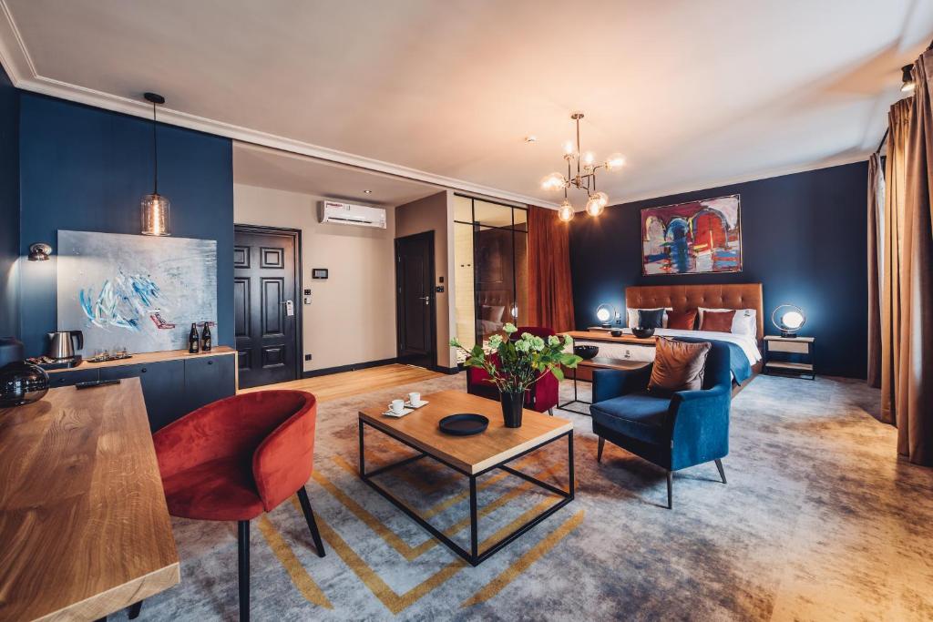 托伦Apartamenty Jan Olbracht的客厅拥有蓝色的墙壁,配有沙发和椅子