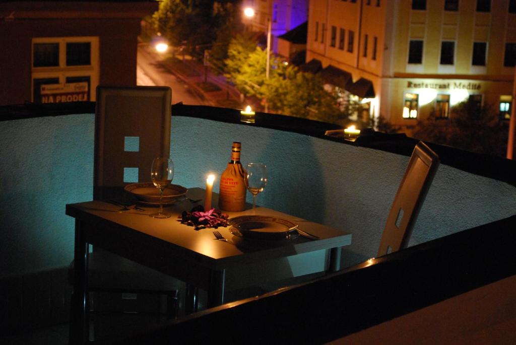 玛丽亚温泉福斯特旅馆的阳台上的桌子上摆放着一瓶葡萄酒和玻璃杯