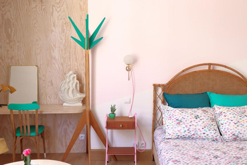 拉沙里泰Le Petit Rivage的一间卧室配有一张床、一张桌子和一盏灯