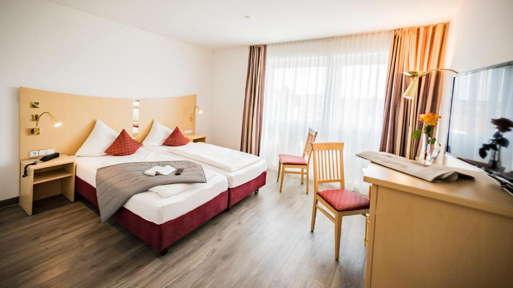 新乌尔姆伽尼城市酒店的配有一张床和一张书桌的酒店客房