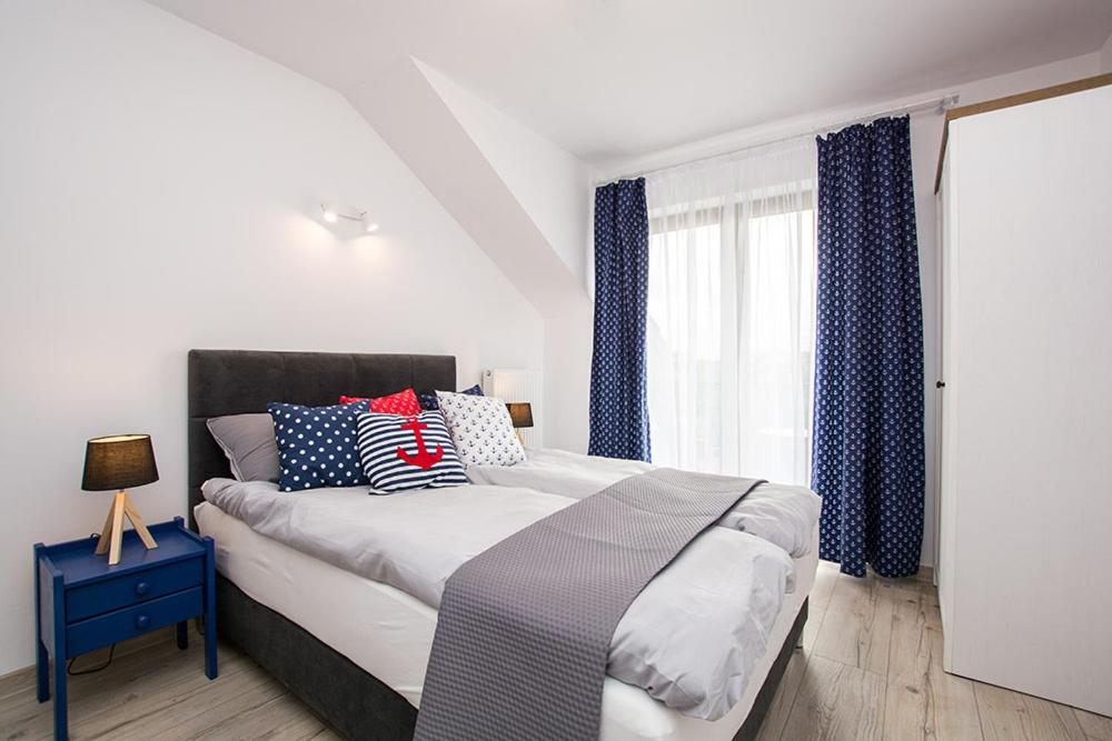 罗威Pod Żaglami的一间卧室设有一张大床和一个窗户。