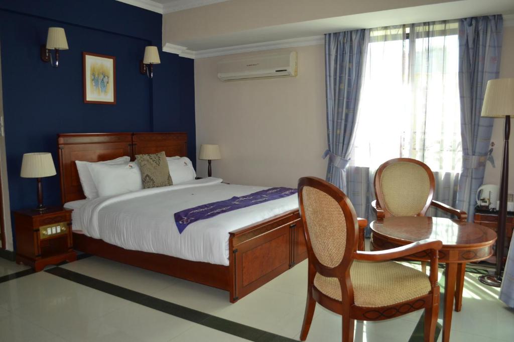 达累斯萨拉姆日航大厦酒店的一间卧室配有一张床、一张桌子和一把椅子