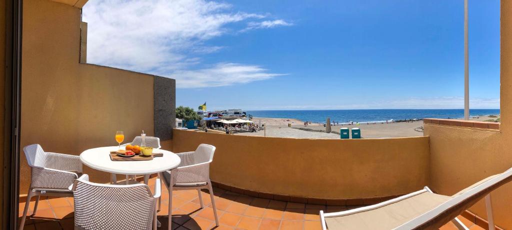 厄尔梅达诺Casa Paradise的海滩景阳台配有桌椅