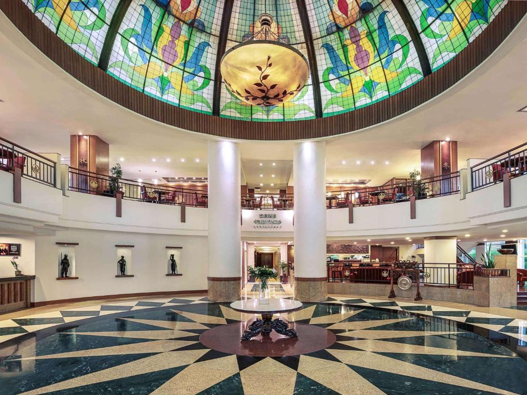雅加达雅加达科塔美居酒店的大型大堂设有大型彩色玻璃天花板