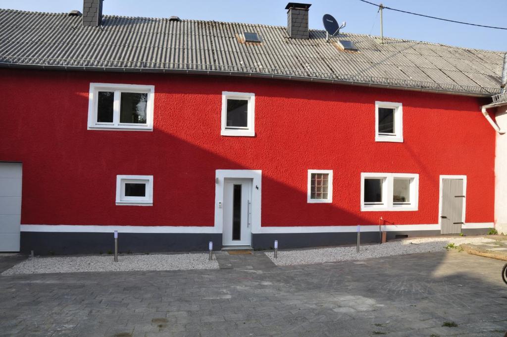 莱米拉斯Pension Schwedenkreuz的红色的房子,有白色的窗户和屋顶